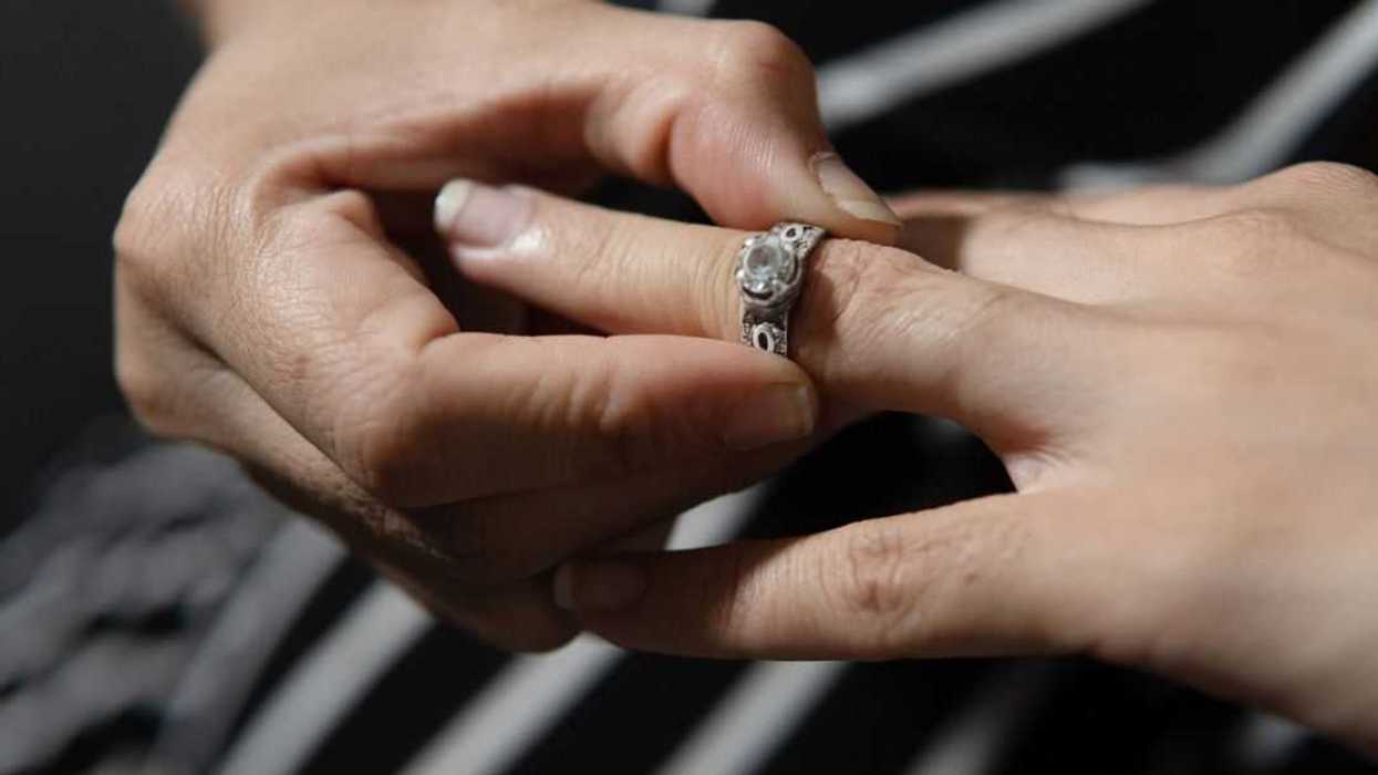 Woman's handsremoving an engagement ring, representing divorce, separation, or a broken marriage
