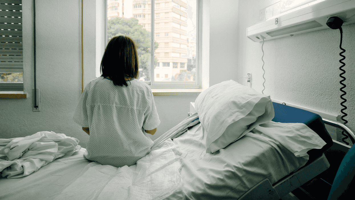 woman sitting alone on hospital bed