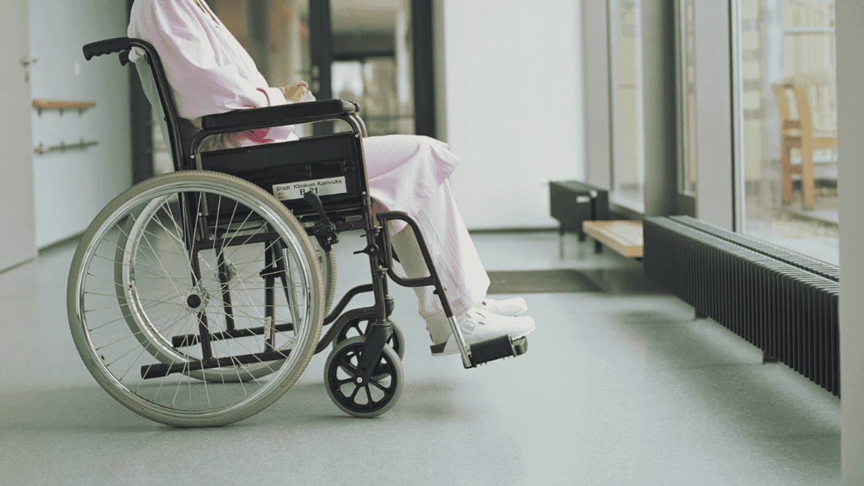 Woman sitting in a wheelchair facing the window.