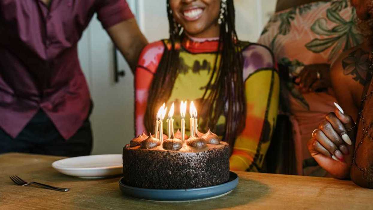 Woman smiling While Looking At Birthday Cake During Dinner Party.