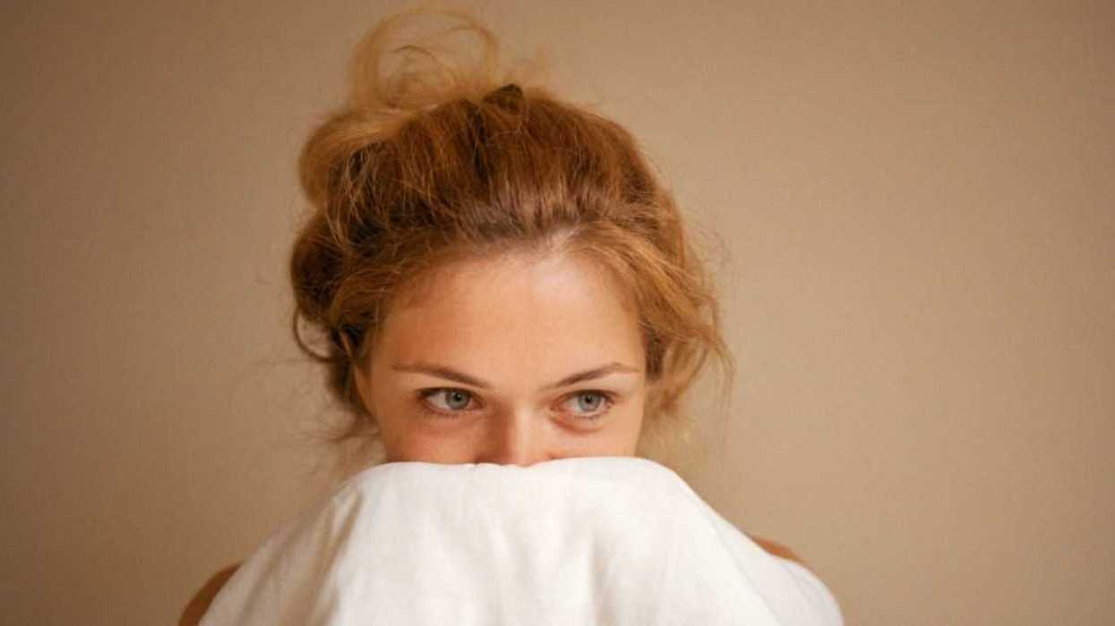 Woman snuggling with white blanket