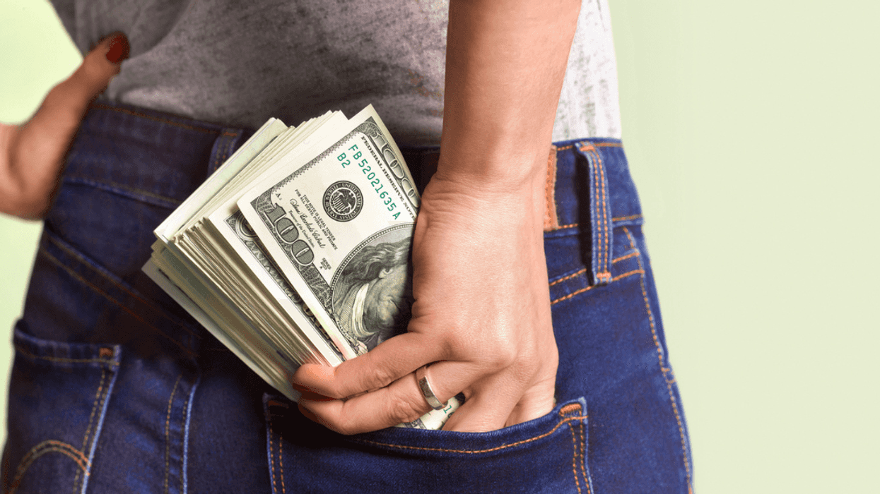 Woman stuffing money in her back pocket