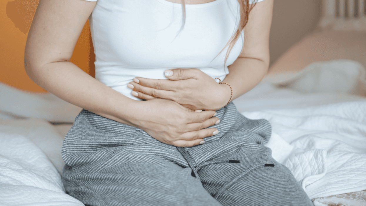 woman suffering from abdominal pain on bed at home
