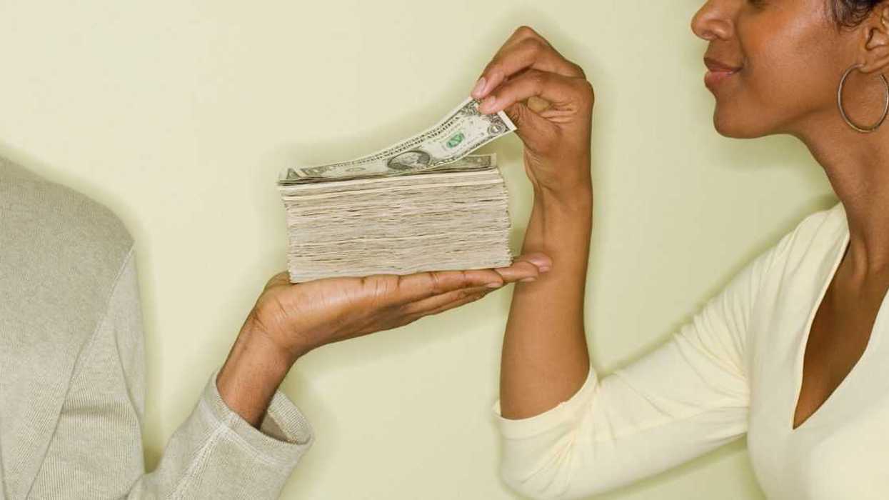 Woman taking money from stack in husband's hand