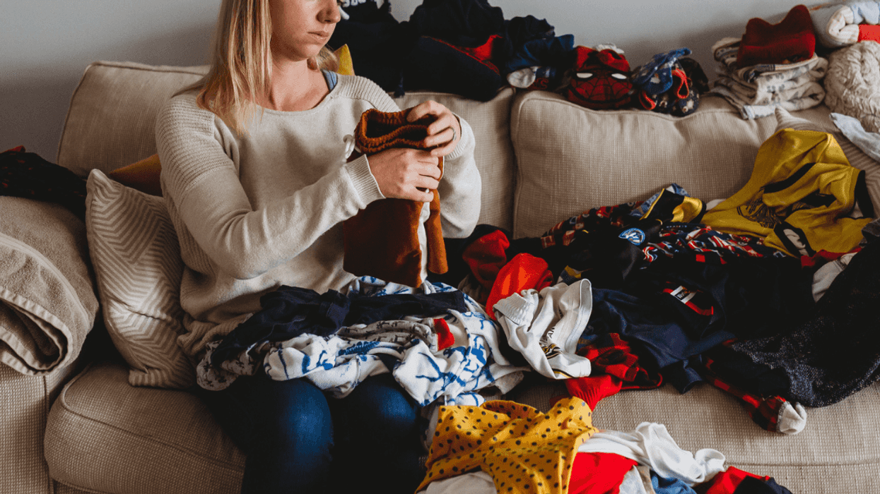 Woman unhappily folding laundry