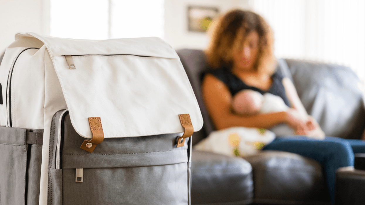 woman with baby in background with diaper bag in foreground