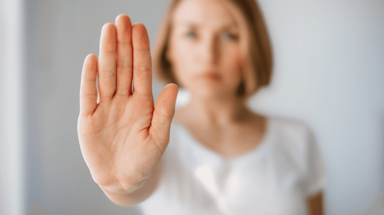 woman with hand up in front of her to indicate "no"