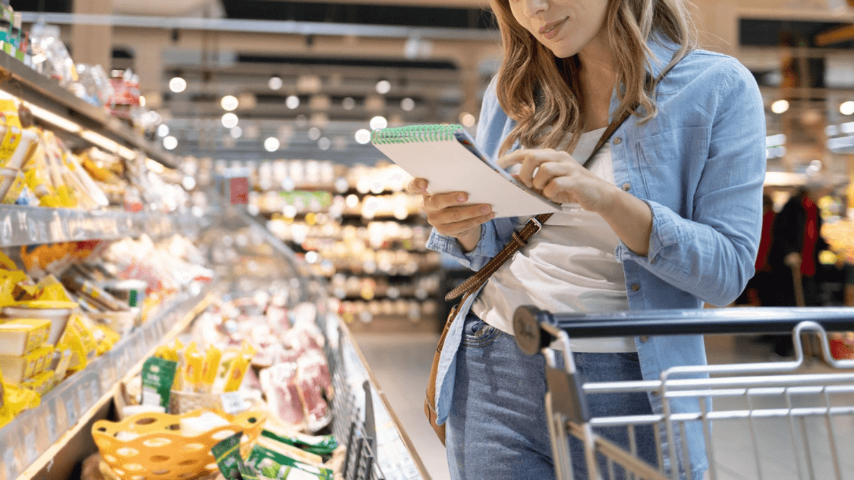 woman with list shopping for groceries