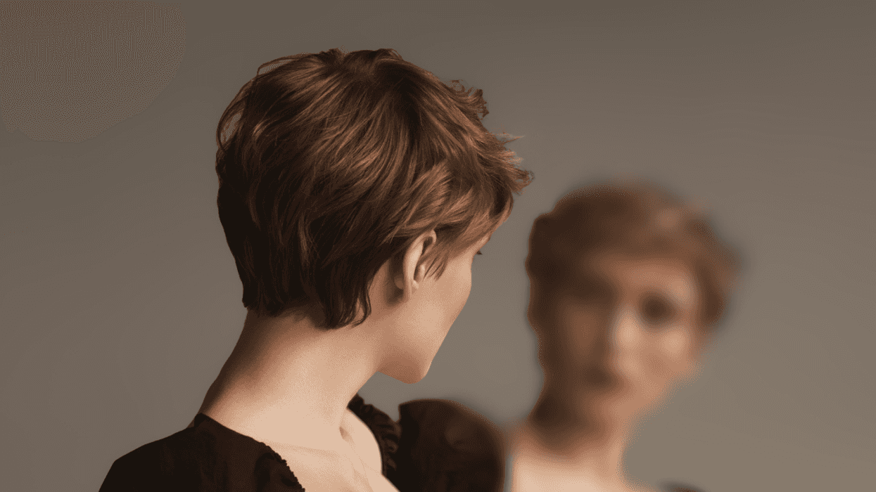 woman with short hair looking in a mirror