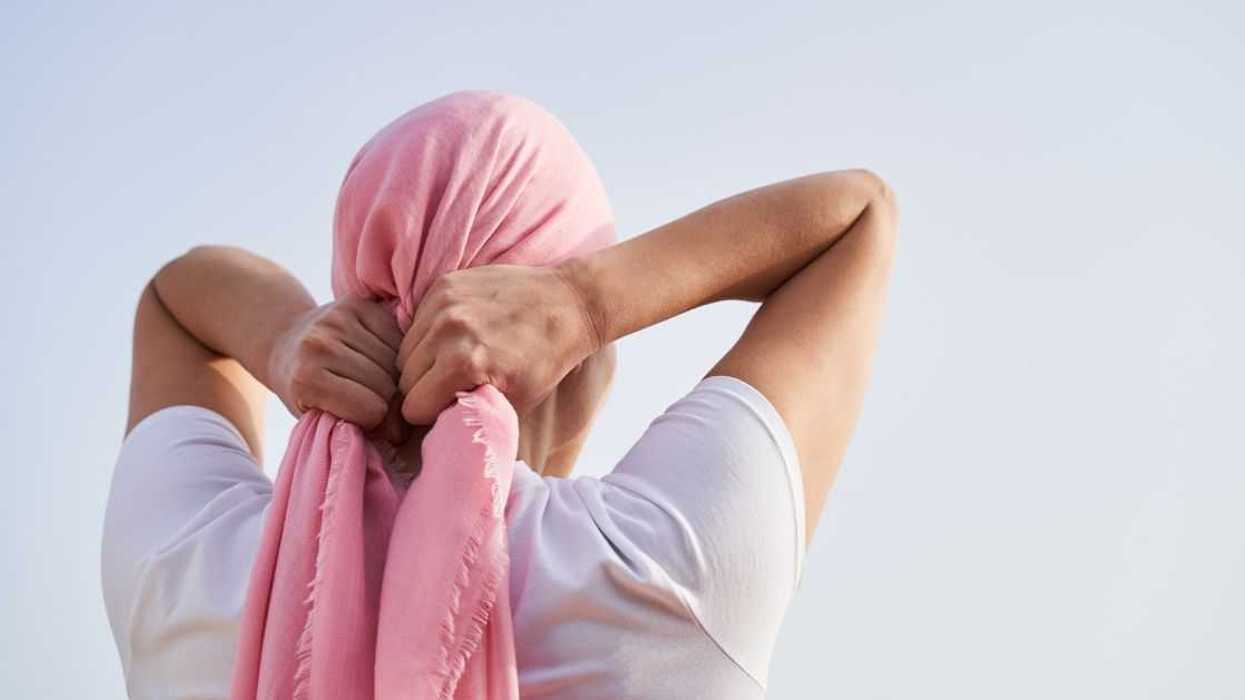 Woman wrapping pink scarf around her head