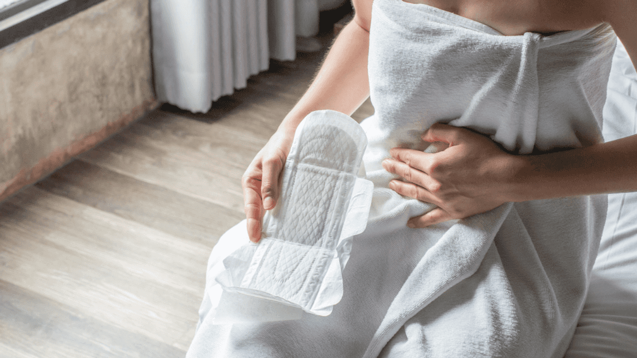 women in white towel holding menstrual pad
