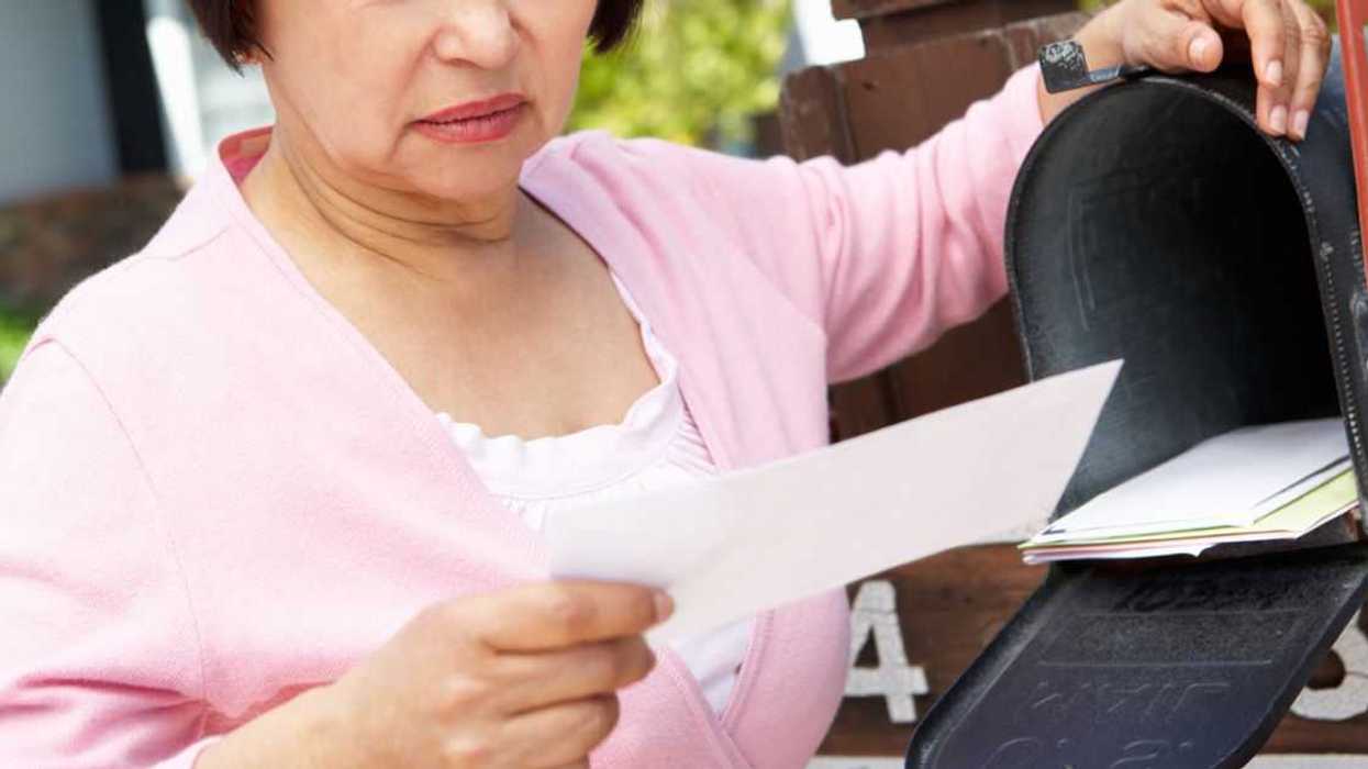Worried older Woman Checking Mailbox