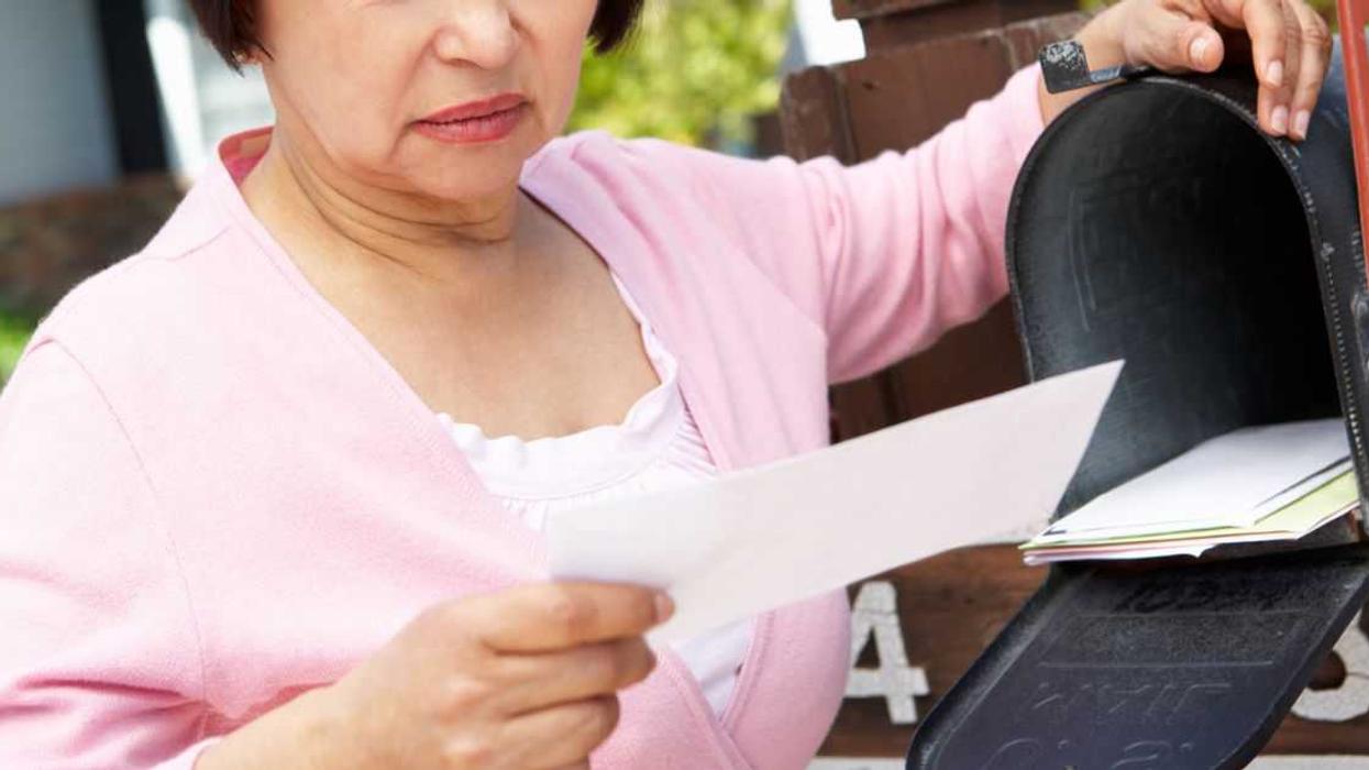 Worried older Woman Checking Mailbox