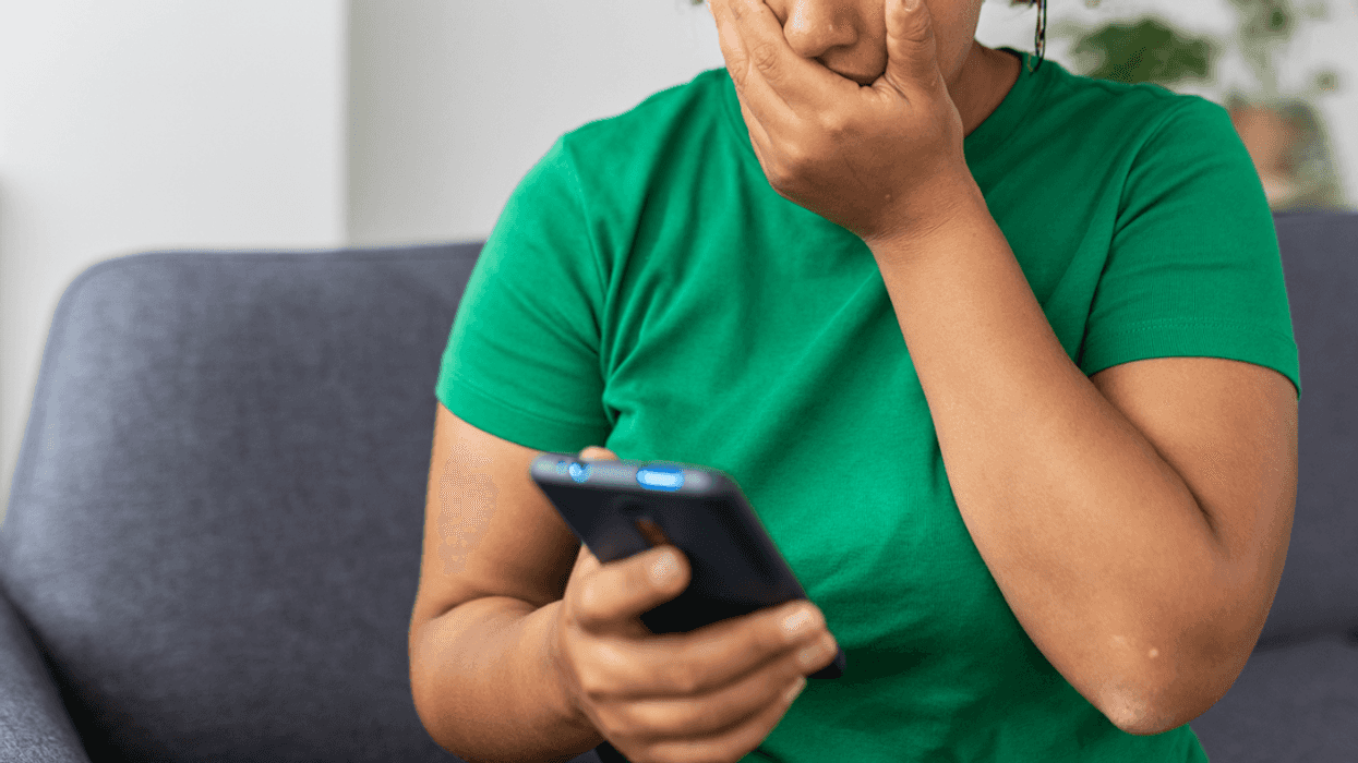 Worried woman looking at smart phone.