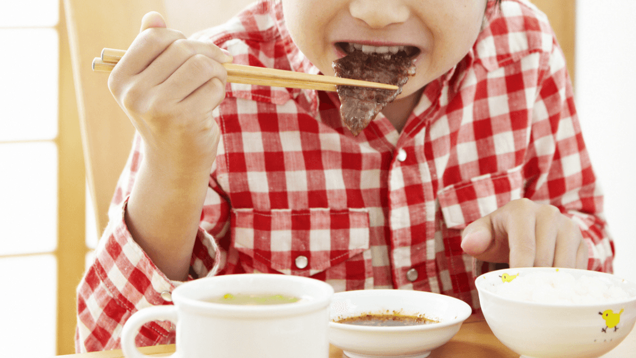 Young boy eating Korean food for lunch at school