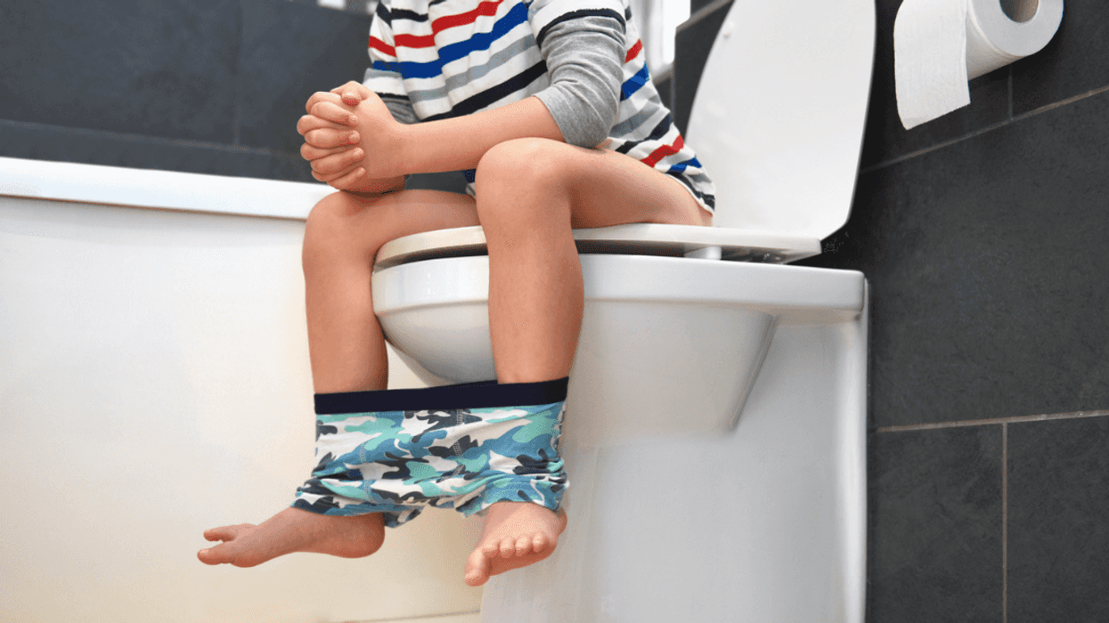 Young boy sitting on toilet