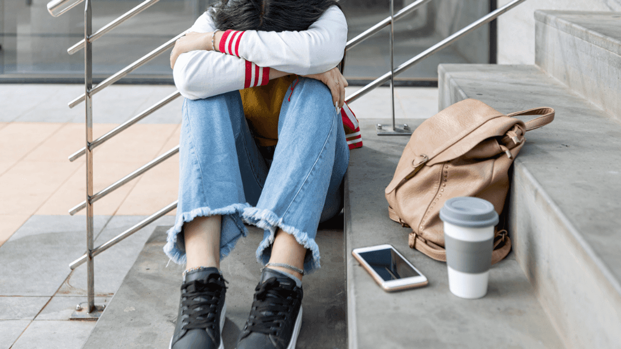 Young girl crying on school steps.