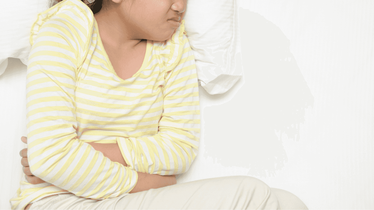 Young girl holding her stomach in discomfort