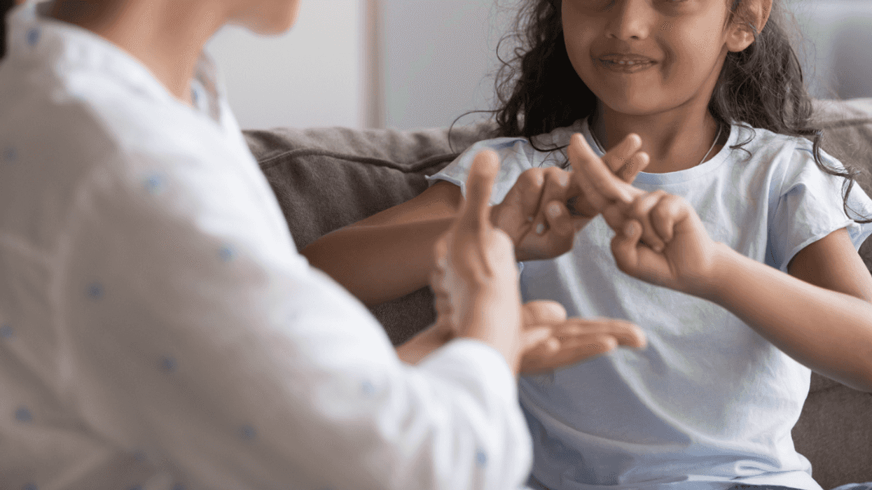 young girl practicing sign language with her mom