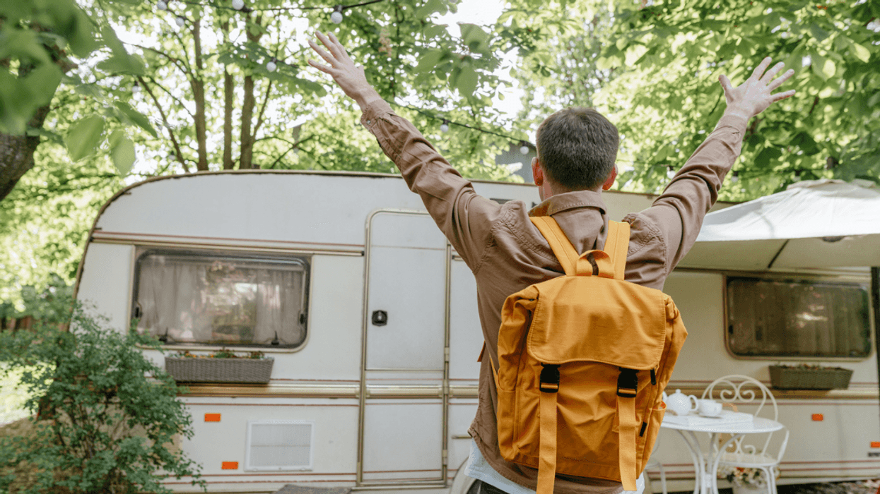 young man excited to see an RV in the woods