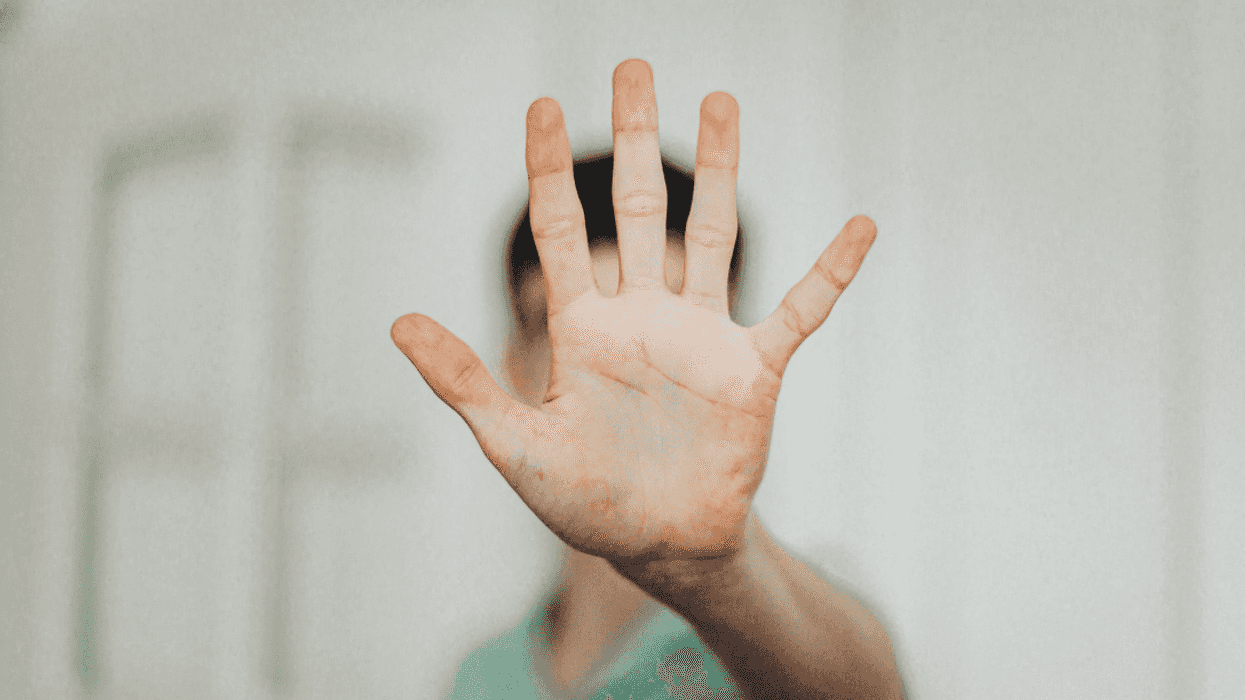 young man with hand up to indicate 'stop'