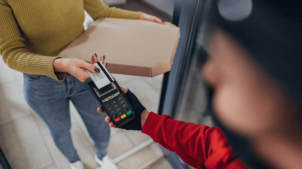 Young woman accepting a Pizza delivery order.