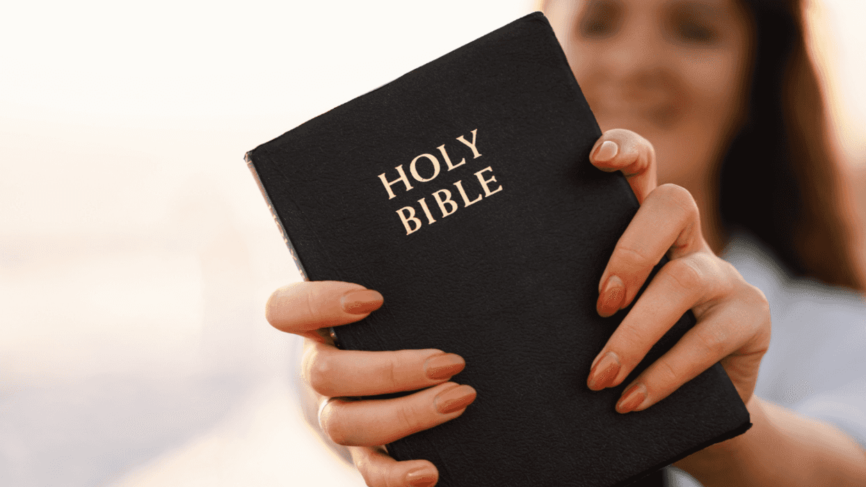 young woman holding out Bible