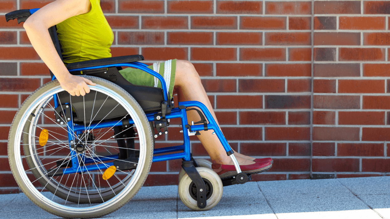 young woman in wheelchair going up ramp