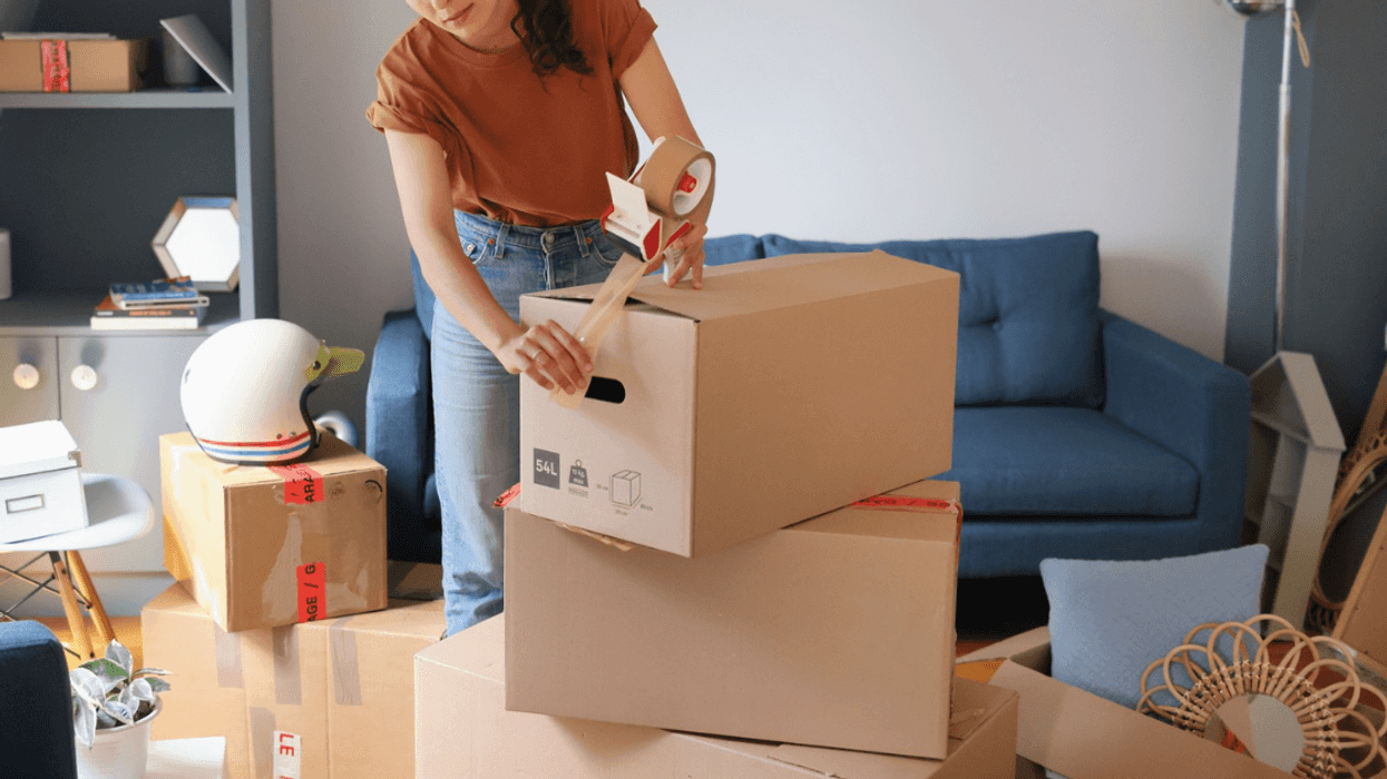 young woman packing moving boxes