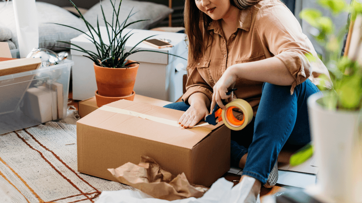 young woman packing moving boxes