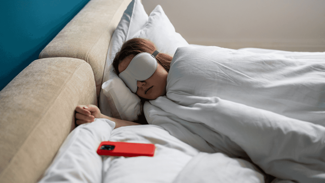 young woman sleeping with her cellphone next to her