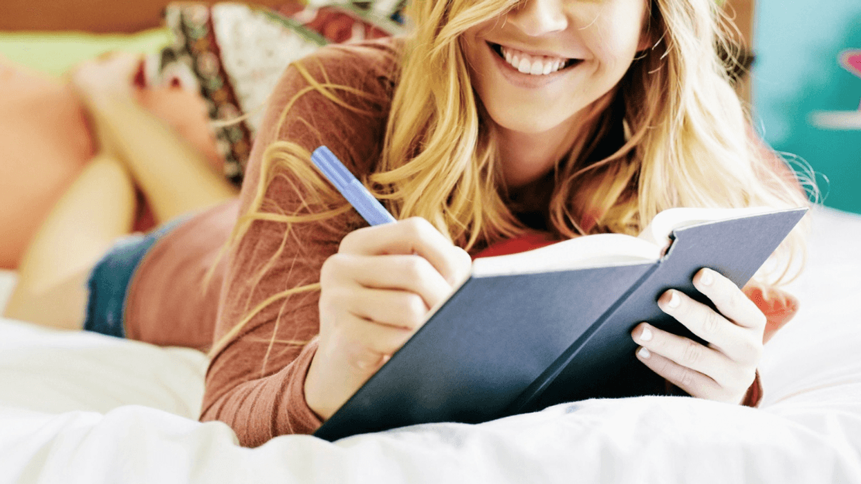 young woman writing in journal