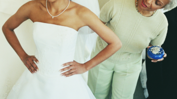 Woman looking skeptically at young woman's wedding dress