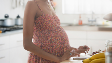 Pregnant woman standing in kitchen