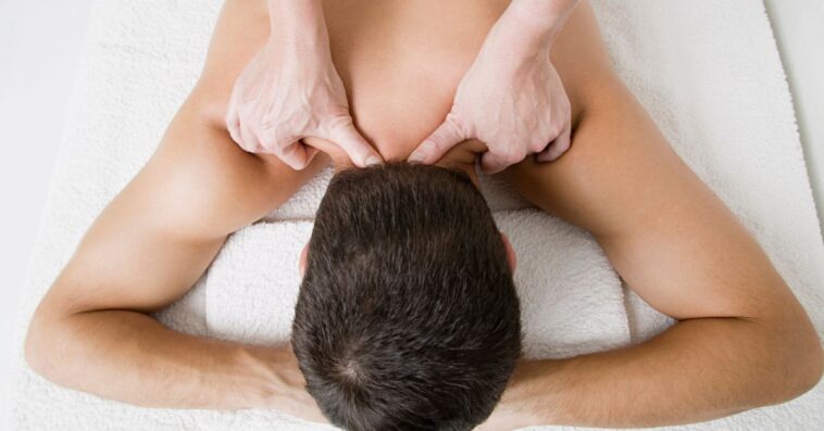 A man facedown receives a massage