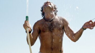 shirtless man with water hose