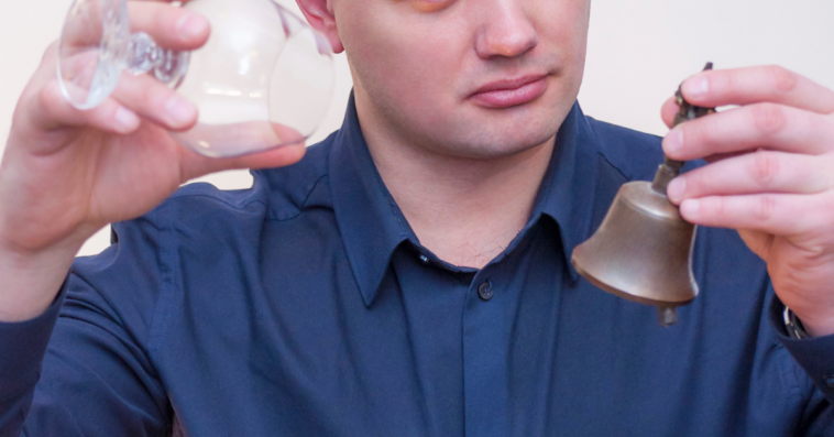 Man ringing small bell when his glass is empty