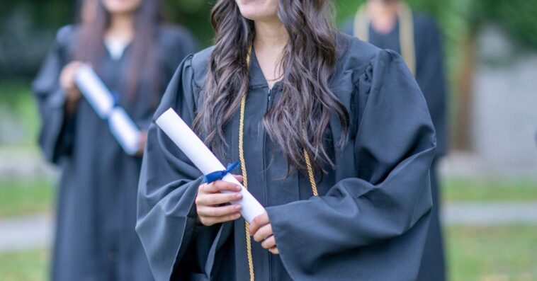 Teenage female graduate holding a diploma