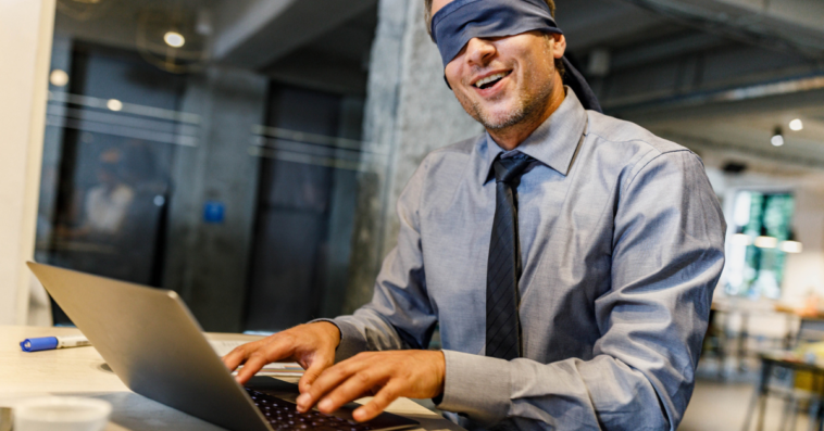 Man attempting to type while blindfolded