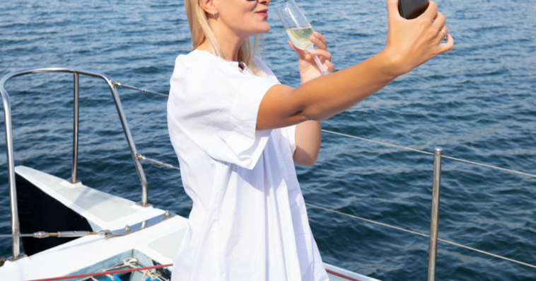 Woman taking selfie on yacht.