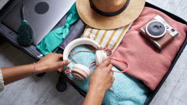 woman packing suitcase with vacation items