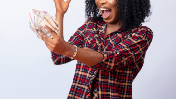 Excited woman holding large amount of cash