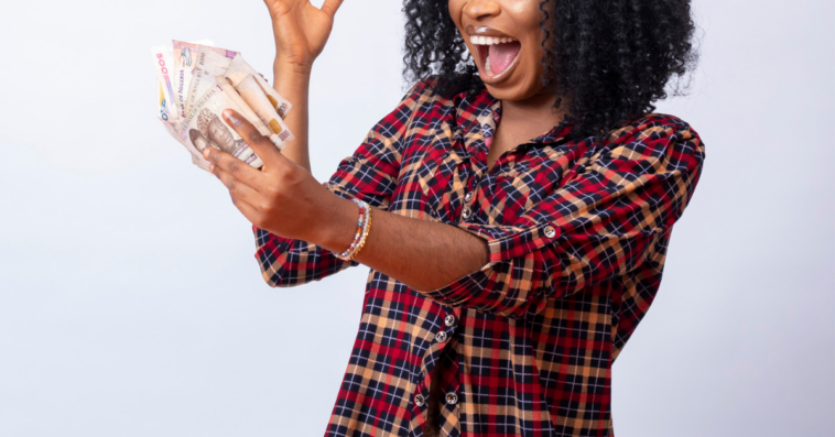 Excited woman holding large amount of cash