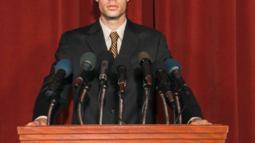 Man at podium giving a statement.