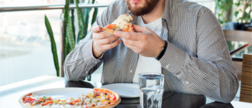 Man eating supreme pizza