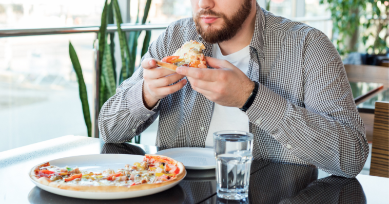 Man eating supreme pizza