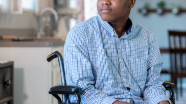 Teen boy in wheelchair in kitchen area