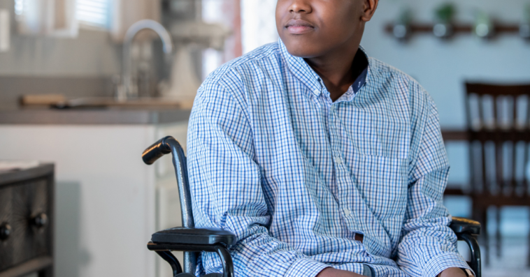 Teen boy in wheelchair in kitchen area