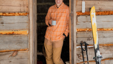Man standing in the doorway of a cabin.