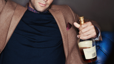 Man holding a bottle of whiskey